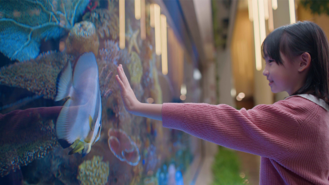 Ties of Pediatric Care - young girl try to touch seafish living in Sunway Medical Centre's aquarium